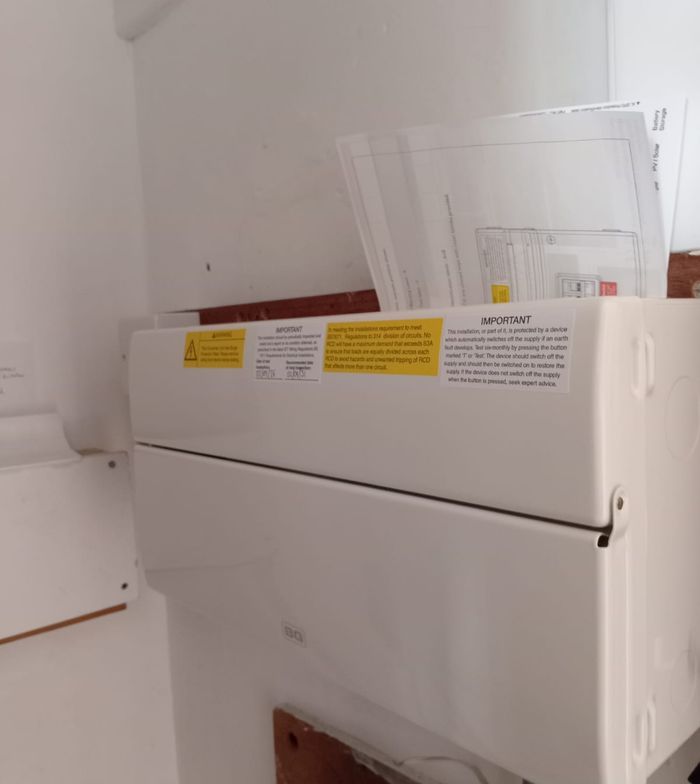 White consumer unit with the cover closed and regulation labels